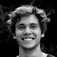 Smiling person with wavy hair against a dark background